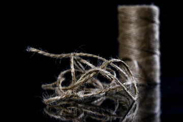 Jute string rolled into a ball. A string on a glass mirror table.