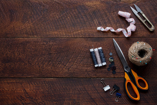 Top view aerial image fashion designer background concept.Flat lay sewing accessory or tailor tool work shop on modern rustic brown wooden at home office desk studio.Space for creative design mock up.