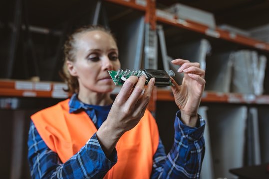 Female worker checking circuit board