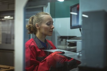 Female worker checking a machine board 