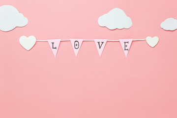 Table top view image of decoration valentine's day background concept.Text sign of season with paper cut clothesline love on beautiful pink sky with cloud.Several objects on pink wallpaper.pastel tone
