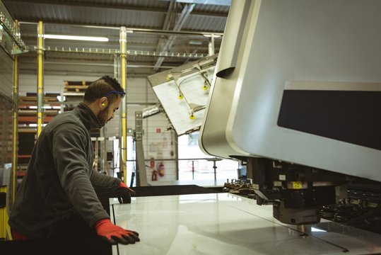 Male Worker Checking A Glass Sheet