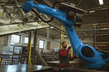 Male worker checking robotic machine