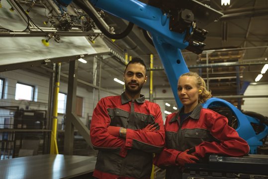 Male and female worker standing together with arms crossed in