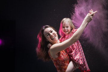 Young mother and small daughter during photoshoot with flour