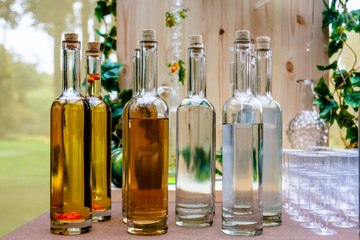 Obraz na płótnie Canvas Transparent bottles of different alcoholic beverages - cordials and liqueurs.