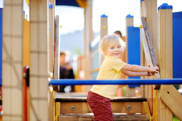 Little boy having fun on outdoor playground/on slide