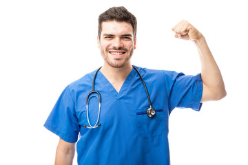Doctor flexing his muscles and showing strength in a studio
