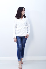 Beautiful asian girl in jeans on a white background