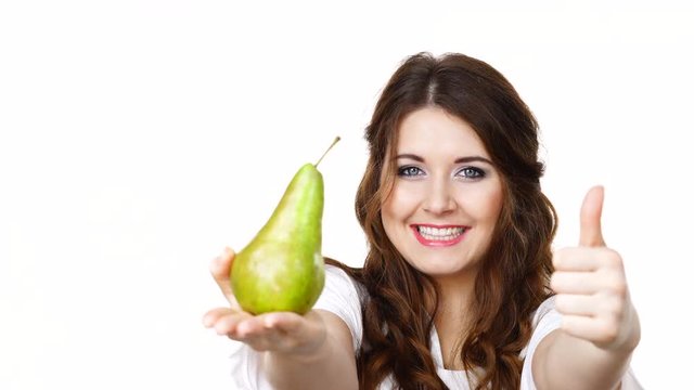 Smiling woman holding and recommend to eat pear fruit, making thumb up hand sign, isolated on white. Focus on face. Healthy eating, dieting concept."