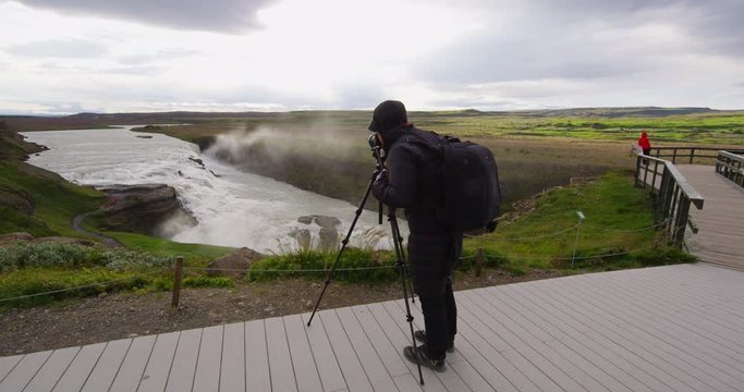 Photographer and tourists at Gullfoss Waterfall on Iceland in Icelandic nature. Tourist looking at Gullfoss aka Golden Falls is a famous tourist attraction and landmark on Icelands Golden Circle,