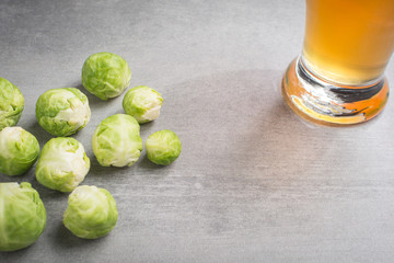 Brussel sprouts and a glass of beer on a stone background