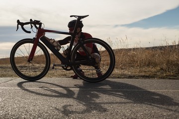 Biker checking his mountain bike on road
