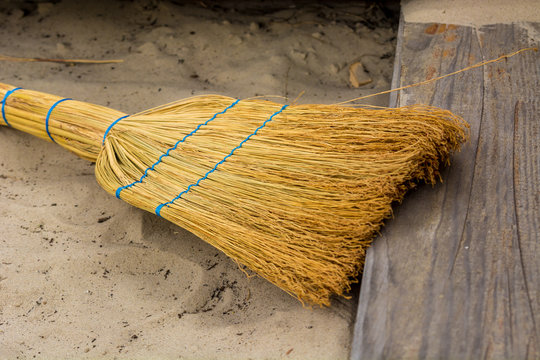 Yellow broom for sweeping the sand in the children's sandbox