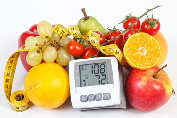 Blood pressure monitor with result of measurement, fruits with vegetables and centimeter