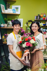 Male florist offering flowers at the counter in the florist shop