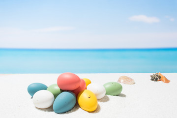 Easter on tropical beach background. Eggs on the white sand. Vacation and travel concept
