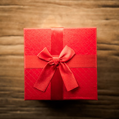 Red gift box on wooden plank. Concept for holiday or valentine day.