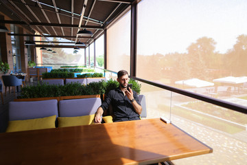American businessman talking by smartphone and charging with pow