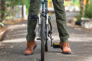 Man with cargo pants riding a bicycle in the garden