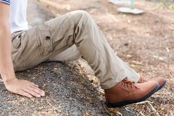 Man wearing brown cargo pants and sitting in the nature park