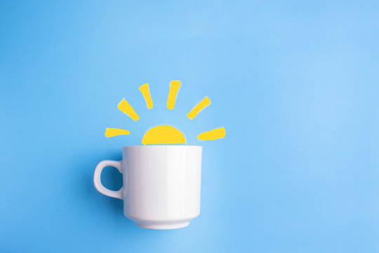 sun and white cup on blue background