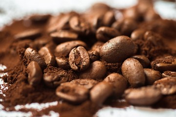 Pile of coffee beans and coffee powder.