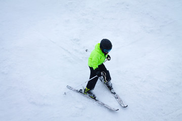 Fototapeta na wymiar Child skiing downhill from the slope