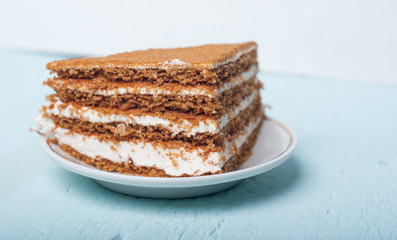 A piece of sand cake on the plate, blue wood background,