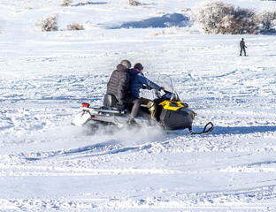 Driving in the snow on a snowmobile on the mountainside at the ski resort