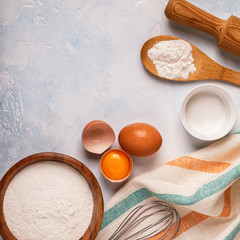 Ingredients for baking  - flour, wooden spoon, eggs.
