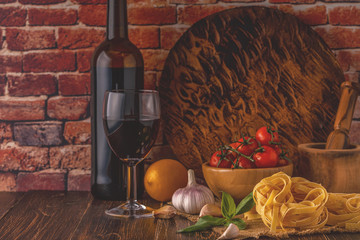 Products for cooking - pasta, tomatoes, garlic, olive oil and red wine.