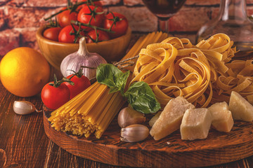 Products for cooking - pasta, tomatoes, garlic, olive oil and red wine.