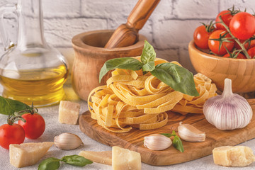 Products for cooking - pasta, tomatoes, garlic, olive oil, basil.