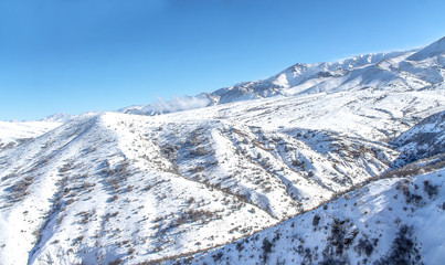 Obraz premium Clouds on snow-capped mountains
