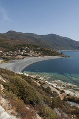Fototapeta na wymiar Corsica, 28/08/2017: la strada tortuosa del versante ovest di Capo Corso, famoso per il suo paesaggio selvaggio, con vista su una delle tante spiagge nere sulla costa 
