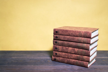 stack of books on wooden table in library