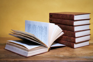 stack of books on wooden table in library