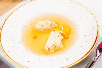 Dumplings in broth with an egg yolk served in a restaurant