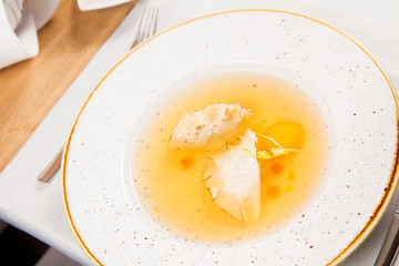 Dumplings in broth with an egg yolk served in a restaurant