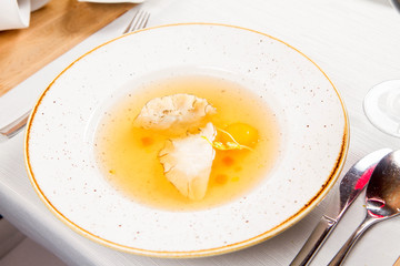 Dumplings in broth with an egg yolk served in a restaurant