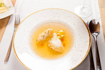 Dumplings in broth with an egg yolk served in a restaurant