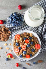 Healthy breakfast concept with oat flakes and fresh berries on rustic background. Food made of granola, muesli. Healthy banana smoothie with blackberries, muslie, strawberries, blueberries and honey.
