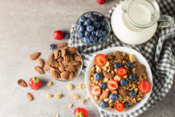 Healthy breakfast concept with oat flakes and fresh berries on rustic background. Food made of granola, muesli. Healthy banana smoothie with blackberries, muslie, strawberries, blueberries and honey.