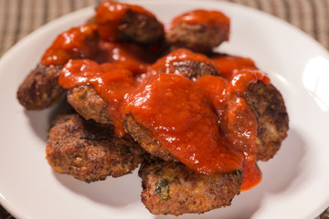Close up of fried meatballs made from pork and beef meat with tomato sauce