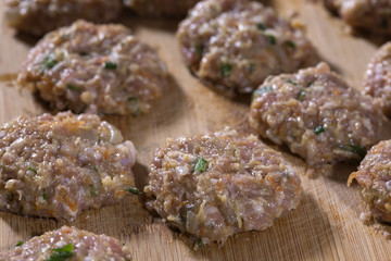 Raw meatballs on the wooden cutting board