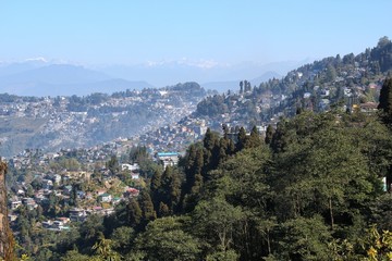 Random houses on a mountain valley with snow clad mountains in background