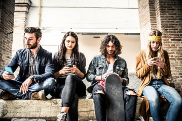 Group of teenagers addicted to their smartphone - obrazy, fototapety, plakaty