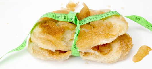 Round domestic burek pie with cheese on the white,tape measure