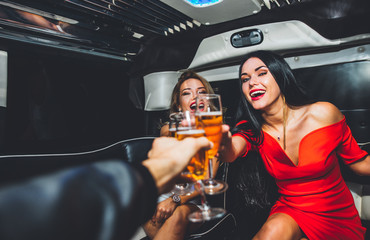 Beautiful girls making party in the limousine - obrazy, fototapety, plakaty